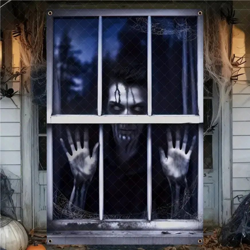 A window decorated with a dark, menacing face and ghostly hands, used as a Halloween curtain banner.