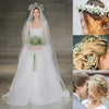 A bridal model wears a white gown and veil adorned with baby's breath flowers.