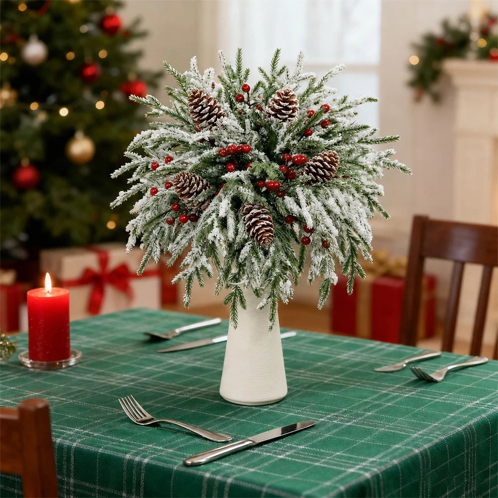 A festive centerpiece of artificial pine branches decorated with red berries and pine cones on a green tablecloth.