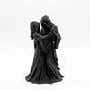A dark romantic sculpture of a couple dressed in hooded cloaks, resembling a Gothic Grim Reaper.