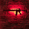 A black gun-shaped LED light fixture mounted on a red brick wall.