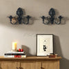 Vintage black wall pendant candle holder mounted on a beige wall above a wooden cabinet.