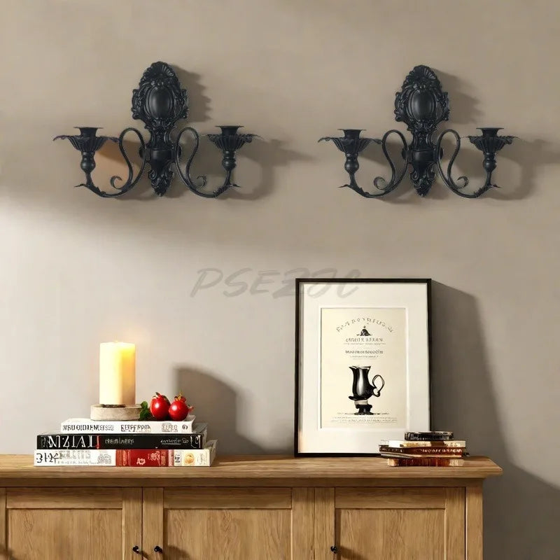 Vintage black wall pendant candle holder mounted on a beige wall above a wooden cabinet.