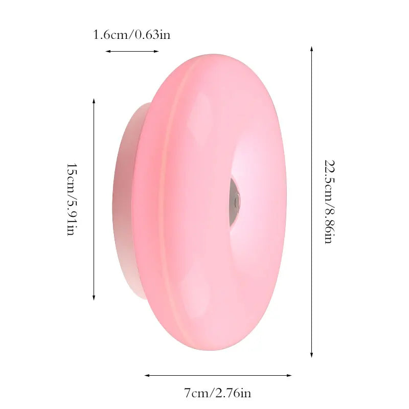 Pinke, donutförmige, wiederaufladbare Wandlampe mit 1,6 cm Dicke und 7 cm Breite.