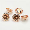 A collection of multi-size round cut cubic zirconia loose stones in warm amber and rose tones.