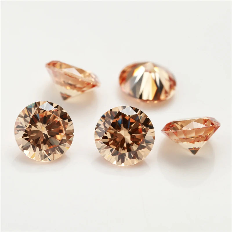 A collection of multi-size round cut cubic zirconia loose stones in warm amber and rose tones.