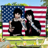 A photo of Jake Webber and Johnnie Guilbert against an American flag backdrop.