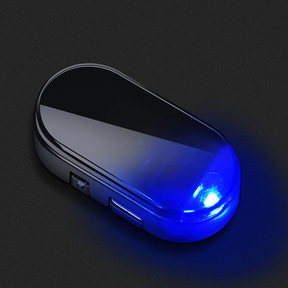 A sleek, oval electronic device emitting a bright blue light on a dark surface.