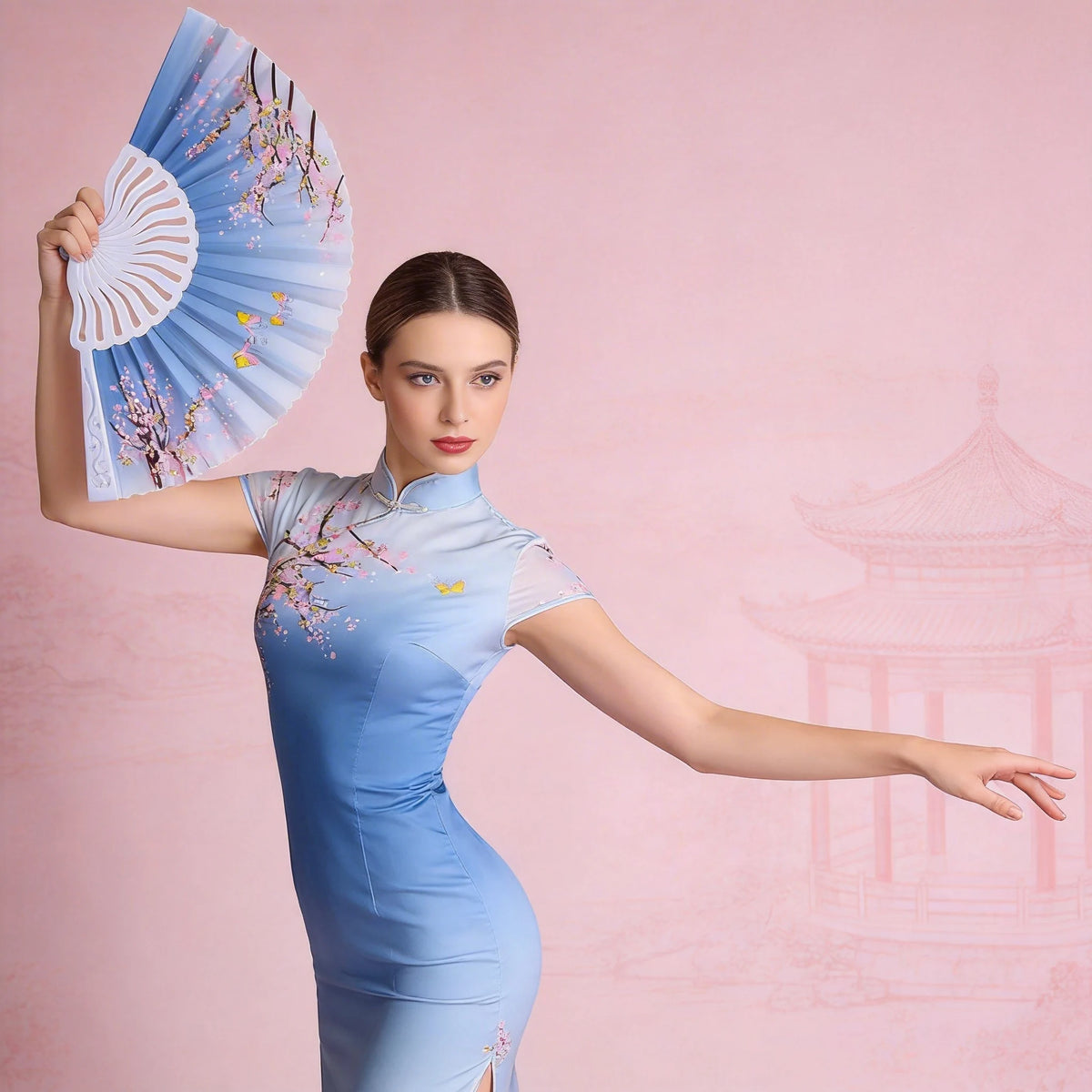 A woman in a light blue dress holds an open, floral-patterned folding fan against a pink background.