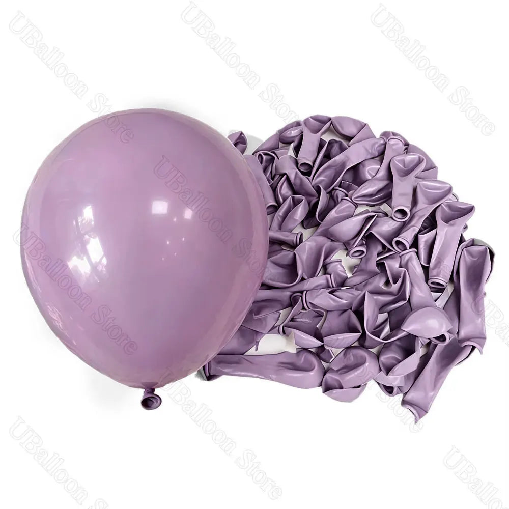 A bunch of lilac and purple latex balloons are shown, tied in ruffled bunches for baby shower or birthday décor.