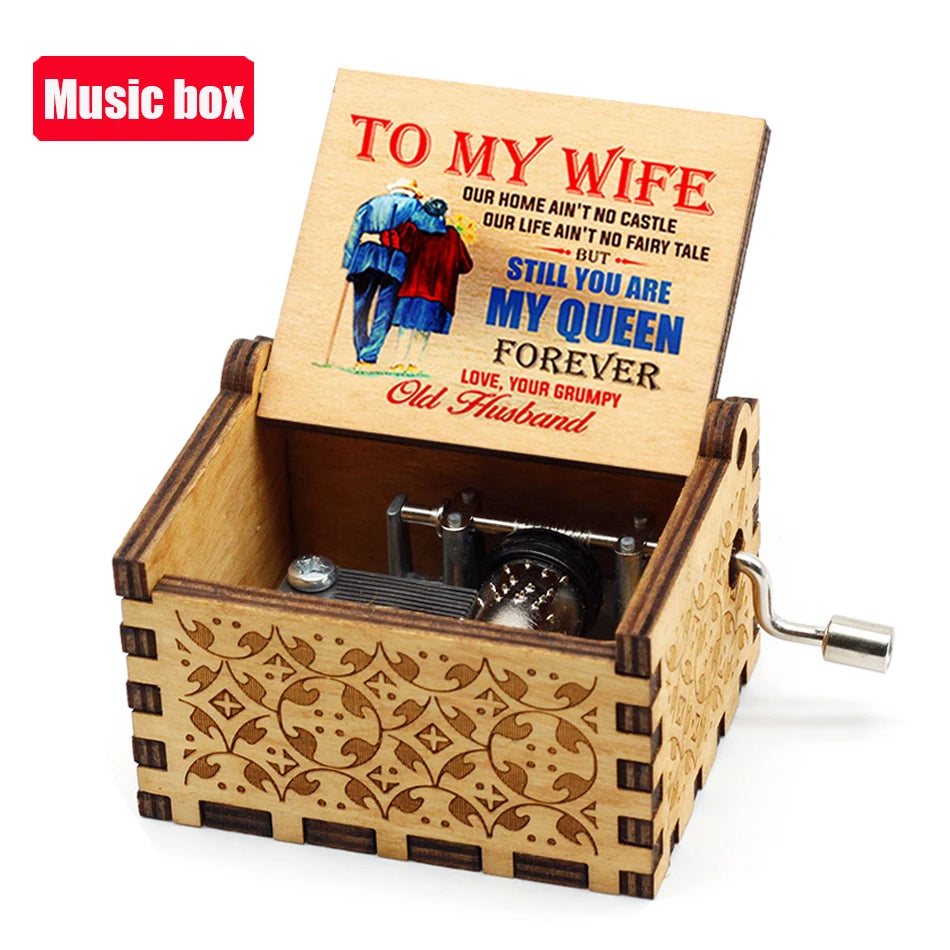 An antique engraved wooden music box with a lid showing text to my wife and a small metal key.