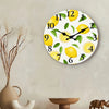 A round wall clock face decorated with yellow lemons and green leaves, featuring numbers 1 through 12.