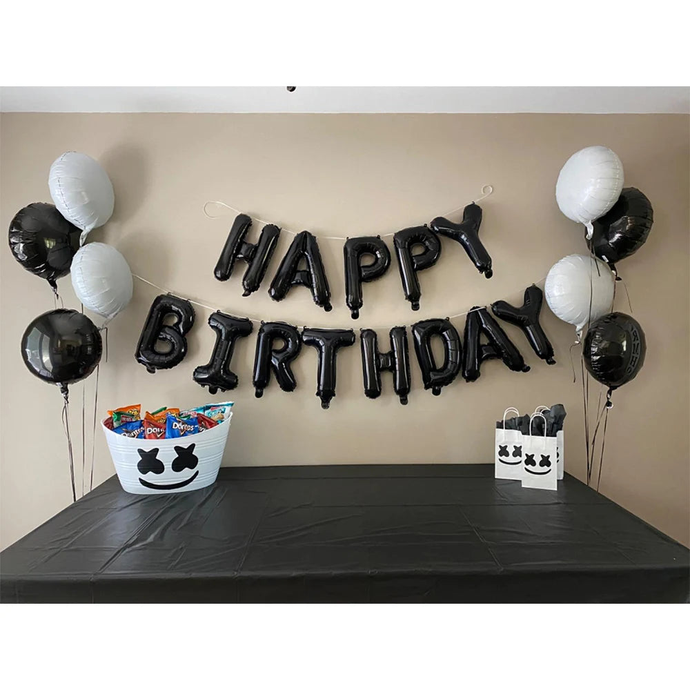 A banner of black foil letter balloons spelling out BIRTHDAY is displayed against a beige wall.