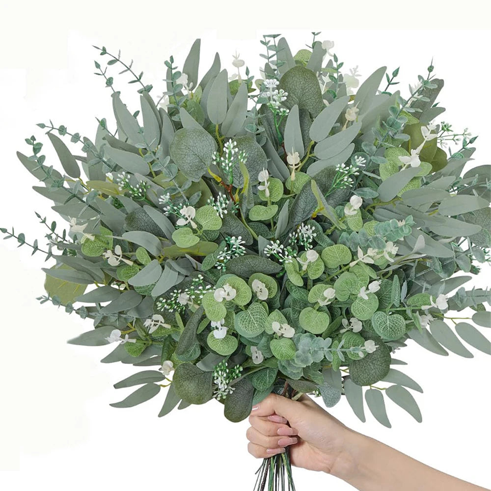 A lush bouquet of mixed artificial eucalyptus leaves and small white filler flowers.