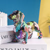 A colorful resin figurine of a dachshund dog standing on a white book.