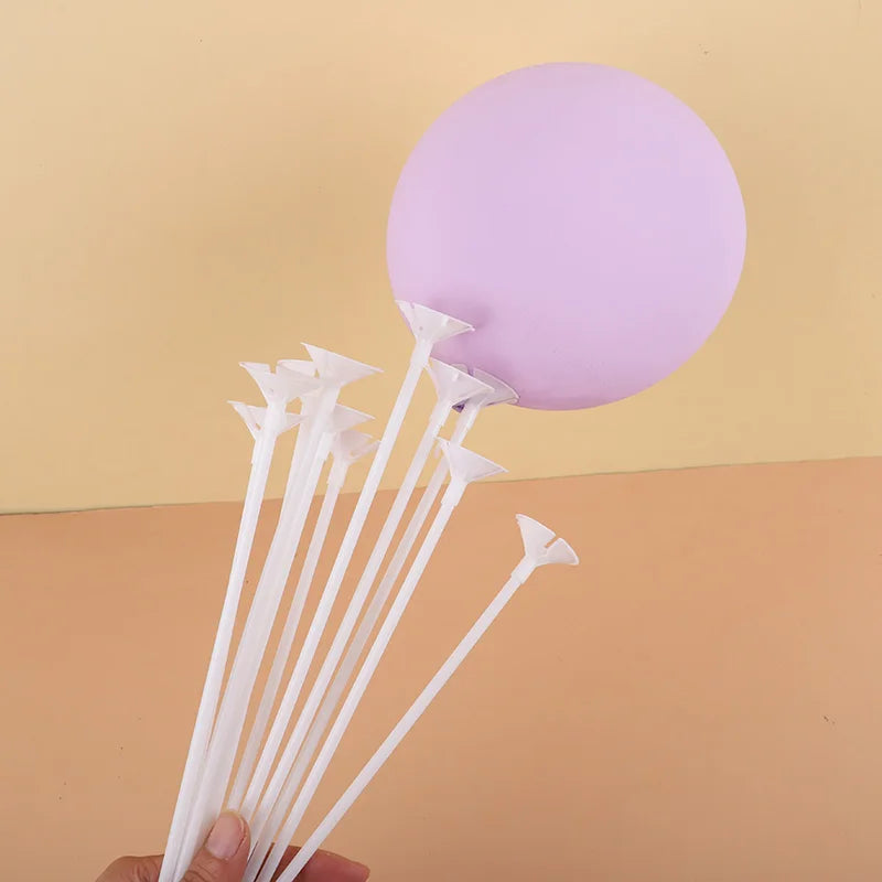 White macaron balloon sticks with holder cups arranged below a purple balloon disk for party decor