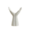A white ceramic hand vase shaped like an open hand, used for home décor.