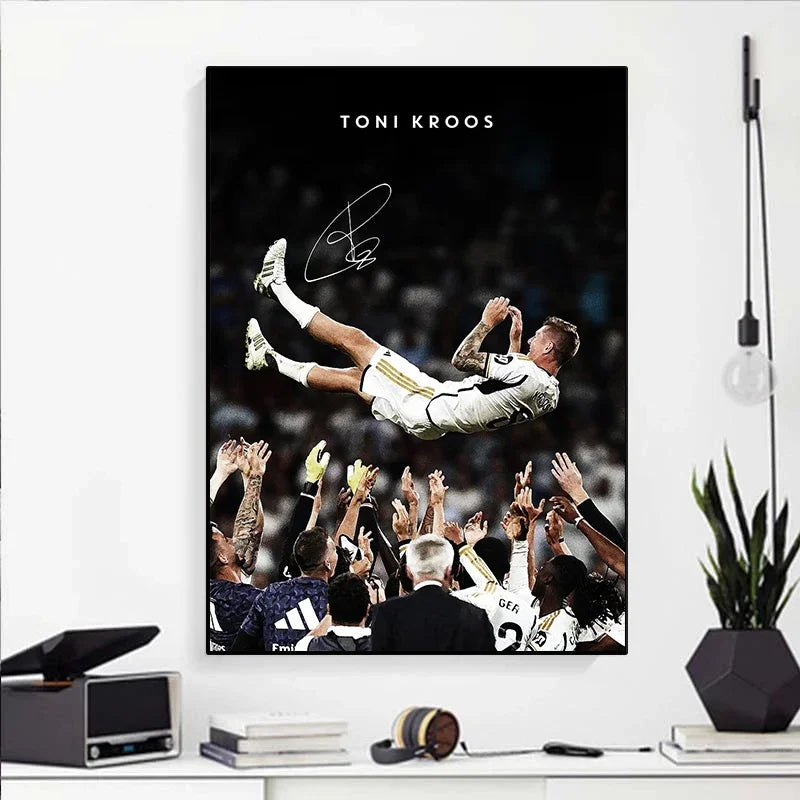 A black and white portrait of Toni Kroos celebrating, featuring a crowd cheering in the background.
