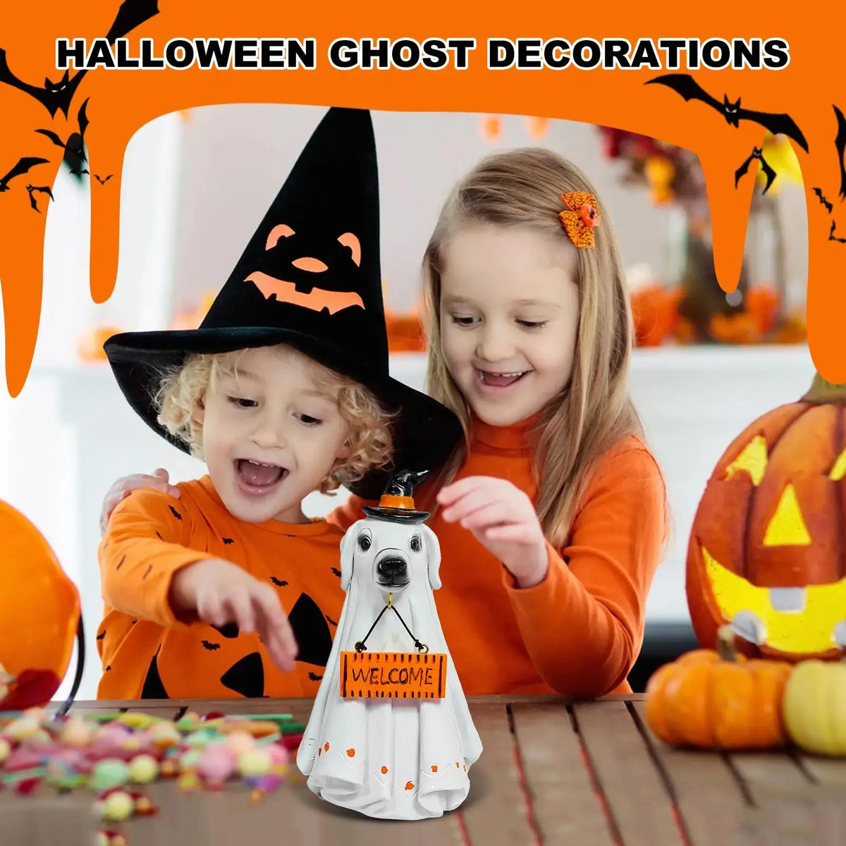 A young girl and boy smiling while holding a white ghost figurine in front of Halloween decorations.