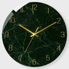 A round black marble-patterned wall clock with gold accents showing the time.