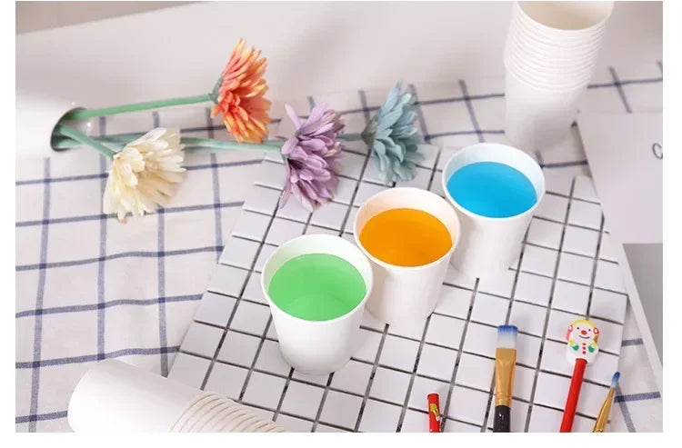 A collection of disposable paper cups in various colors, including orange, green, and blue, arranged on a checkered surface.