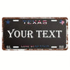 A dark metal license plate sign with the word TEXAS and space for custom text, featuring stars and an American flag motif.