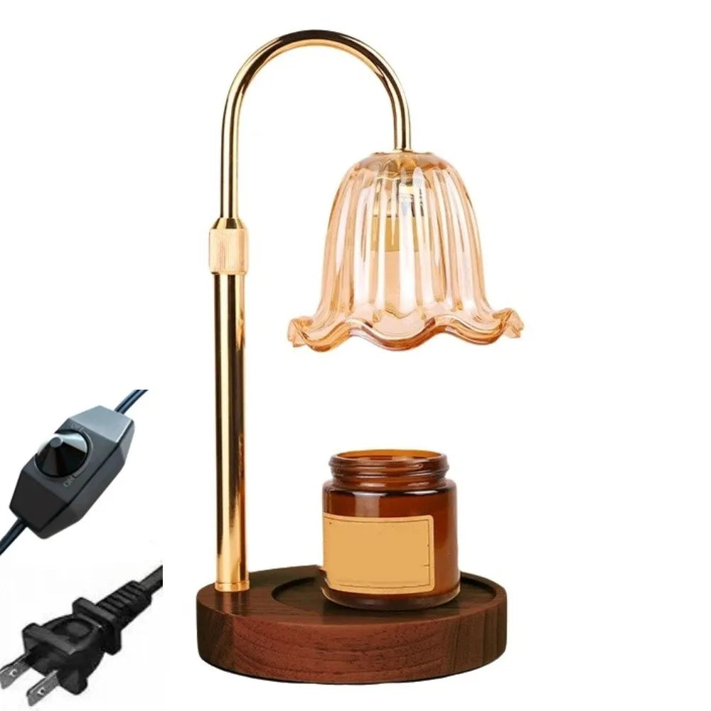 A gold-toned adjustable height aromatherapy candle warmer lamp with a glass shade and a wooden base.