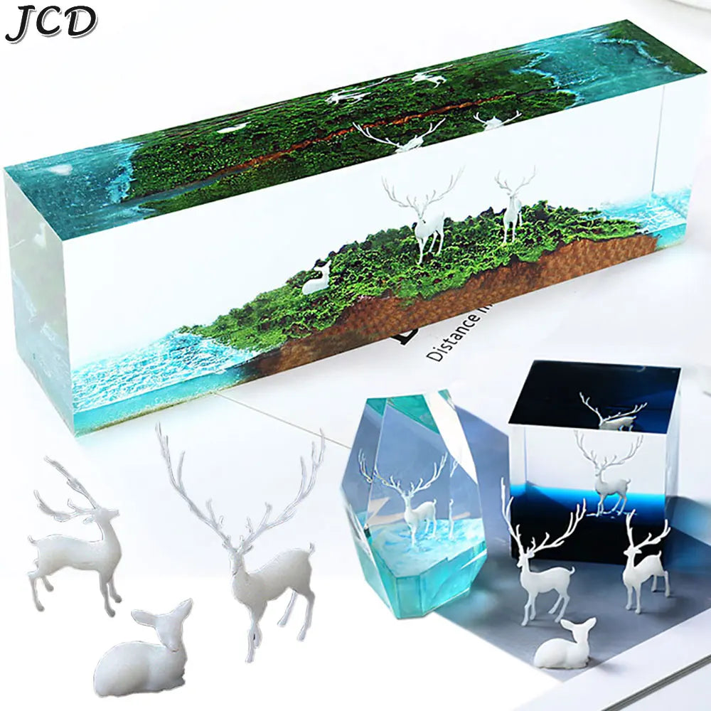 A rectangular resin landscape ornament featuring a forest, water, and deer figures.