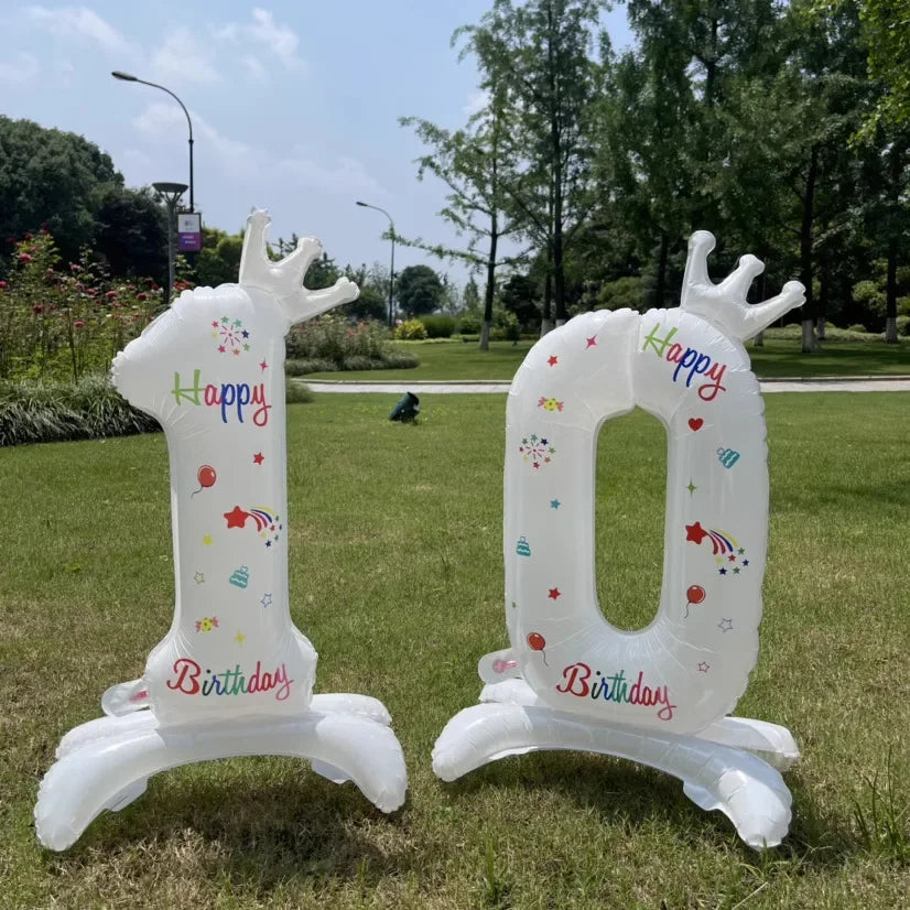White standing foil balloon shaped like the number 0 with a crown and birthday text