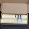 A cardboard box containing four white flameless LED candles and a remote control.