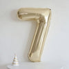 A large champagne gold foil number balloon shaped like the number 7 displayed against a white background.
