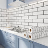 A kitchen backsplash featuring white subway tiles and blue cabinetry with rolled white and black peel-and-stick wallpaper.