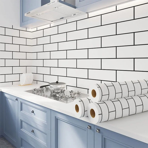 A kitchen backsplash featuring white subway tiles and blue cabinetry with rolled white and black peel-and-stick wallpaper.