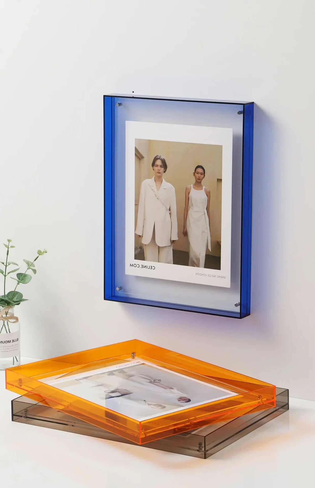 Moderner Acrylfoto-Displayrahmen mit einem gerahmten Foto von zwei Models in heller Kleidung.