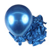 A single shiny blue latex balloon resting on a pile of crumpled blue foil balloons for party decor.