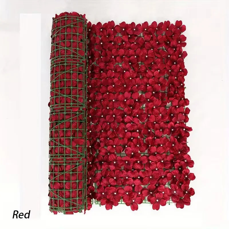 A dense screen of artificial red cherry blossoms used as a privacy fence or decorative screen.