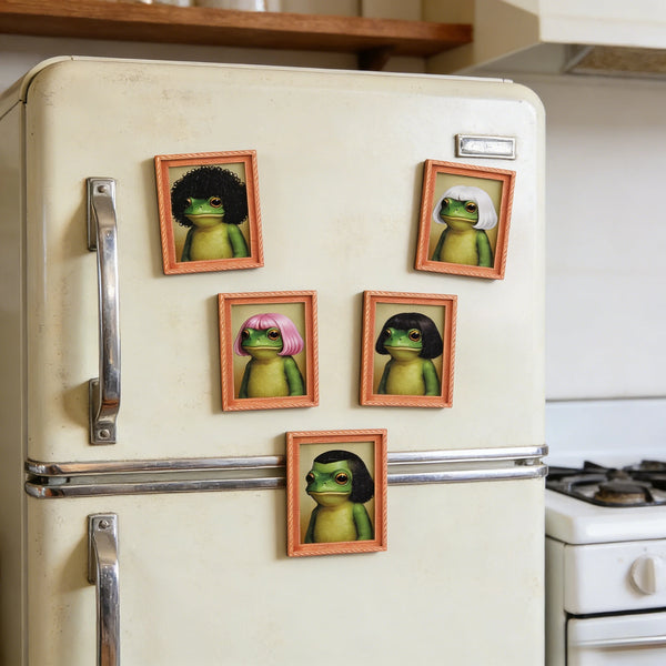 A vintage refrigerator decorated with several framed photos of whimsical frogs in wigs.
