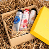 Drei Flaschen Occitane Rose Eau de Cologne in einer Kartonbox mit zerknülltem Papierfüllmaterial.
