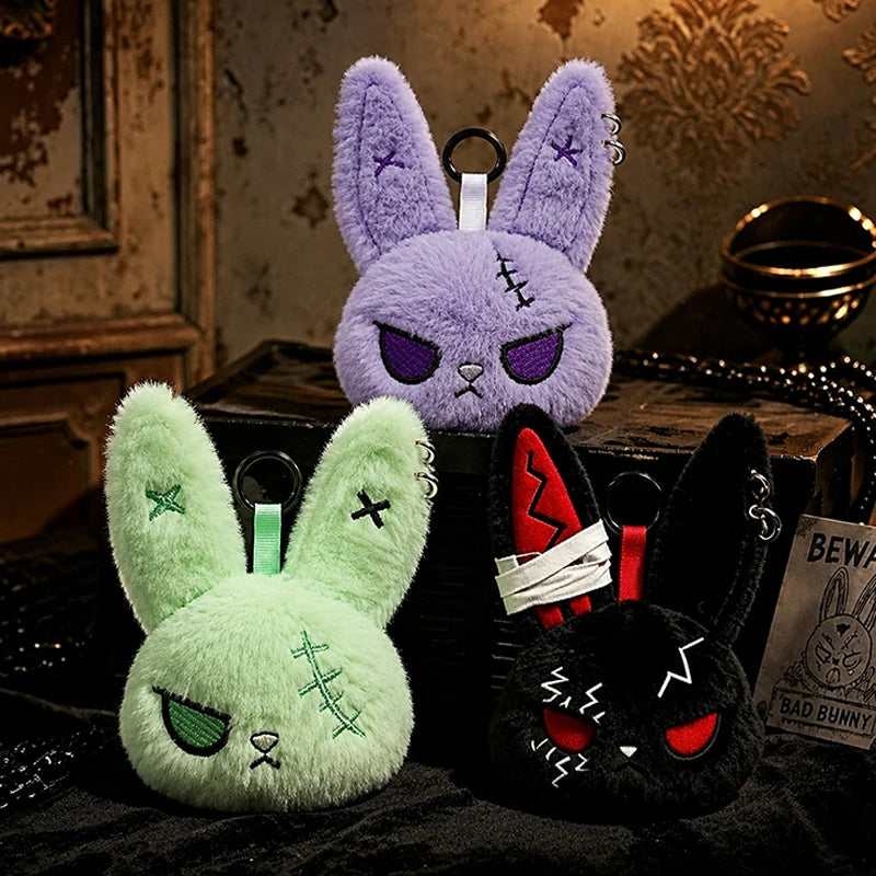 A purple bunny plush keychain with purple ears and a green bunny plush with green ears.