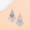 Boucles d'oreilles pendantes en argent, bohèmes turquoise avec charms, sur fond clair