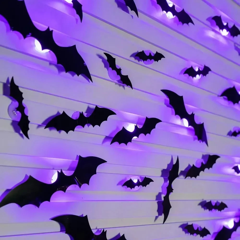 A wall decorated with black bat shapes glowing purple light for Halloween