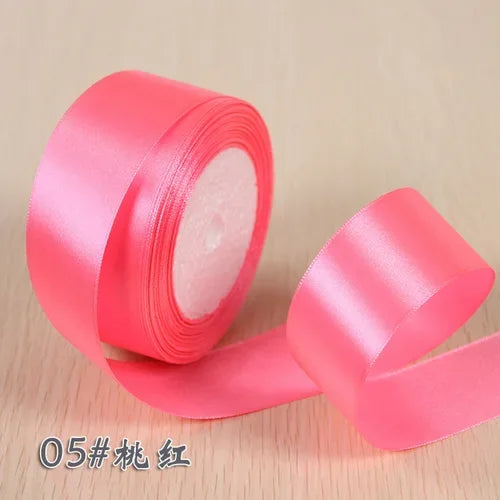 Roll of bright pink silk satin ribbon for gift wrapping and craft projects