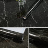 A roll of black marble contact paper is shown lying on a dark marbled surface.