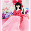 A pink princess ball-jointed doll with black hair wearing a pink satin dress and a large red bow, surrounded by flowers.