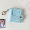 A light blue mini snap button photo album with a silver chain attached, featuring a heart design and Korean text.