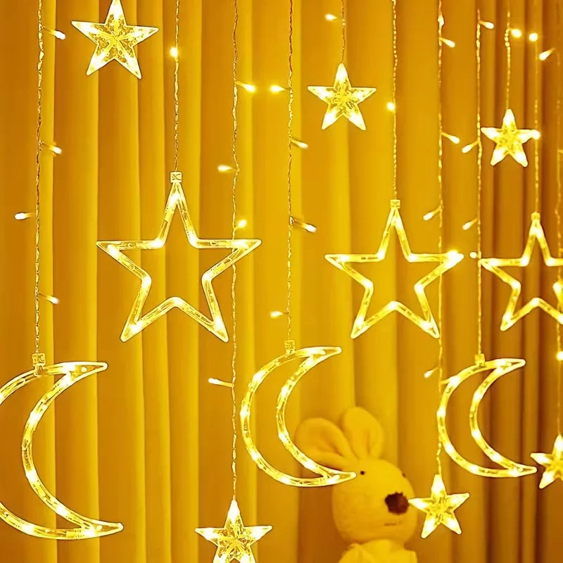 Golden star and crescent moon LED string lights hanging against a yellow curtain backdrop