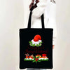 Black tote bag featuring a festive Christmas design with gifts and holly.