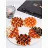 A plate of realistic waffle food replicas including waffles, syrup, and a glass of pink dessert.