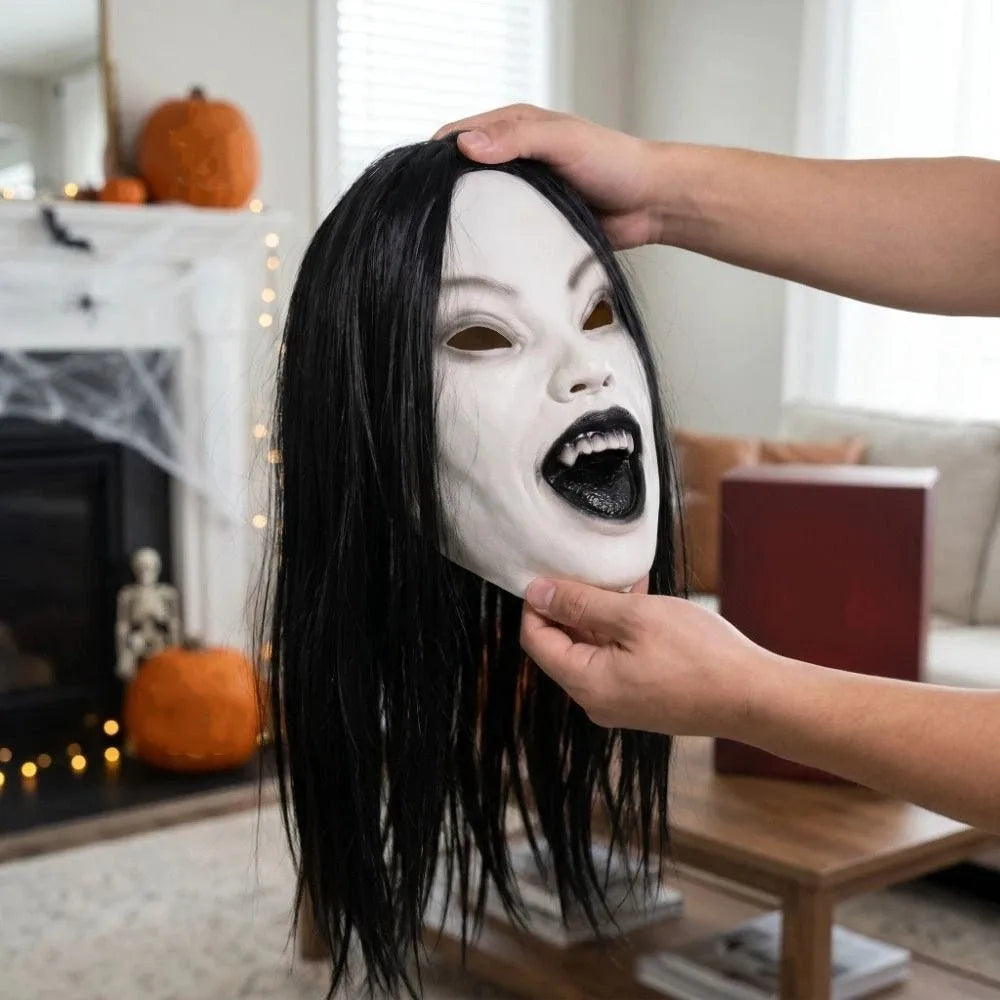 A person is applying white latex makeup to a face while it is styled with long black hair.