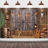 A rustic western backdrop featuring a wooden barn door, hay, antique tools, and guitar with hanging lights.